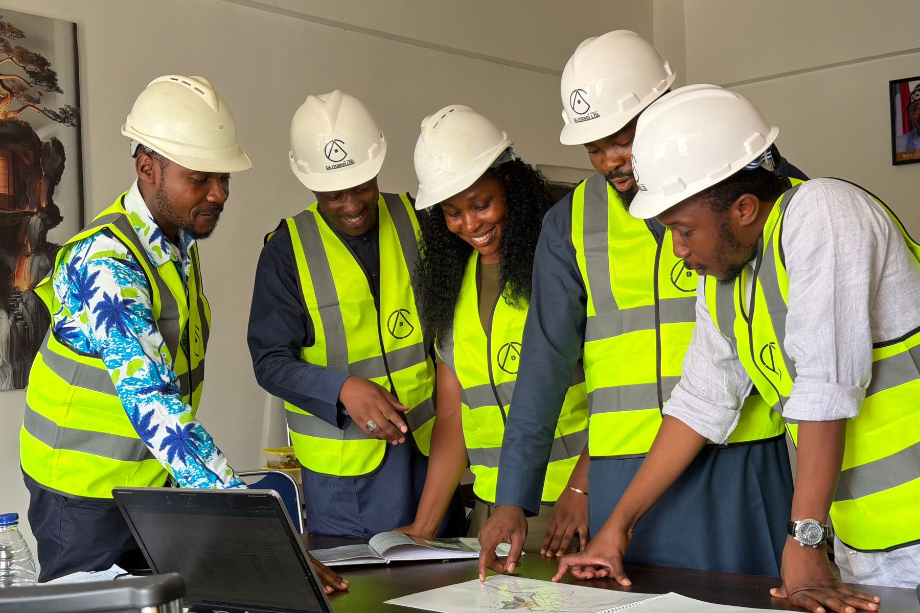 A construction team in hard hats reviewing blueprints and costs around a table